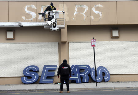 Workers remove a sign from the outside of a Sears department store one day after it closed as part of multiple store closures by Sears Holdings Corp in the United States in Nanuet, New York, U.S., January 7, 2019. REUTERS/Mike Segar