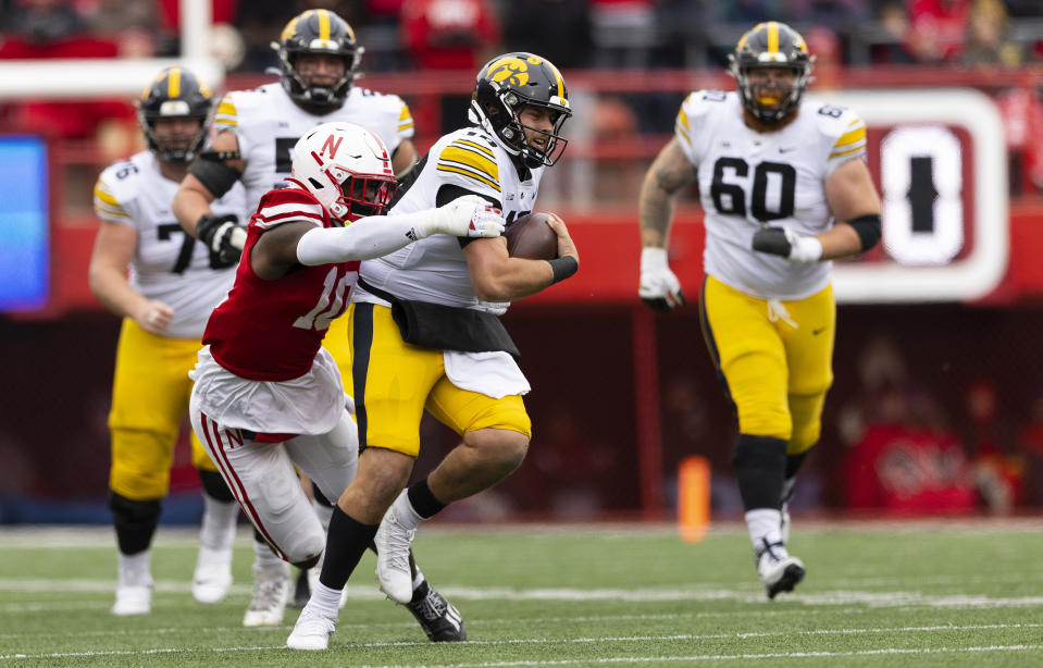 Nebraska's Jimari Butler, left, tackles Iowa quarterback Deacon Hill during the first half of an NCAA college football game Friday, Nov. 24, 2023, in Lincoln, Neb. (AP Photo/Rebecca S. Gratz)