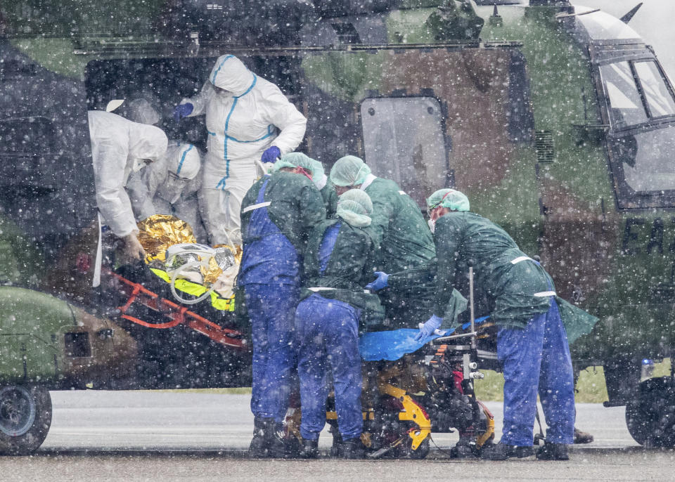 FILE - A coronavirus patient from Metz in France is transported from a military helicopter for treatment at the University Hospital in Essen, Germany, March 29, 2020. Two COVID-19 coronavirus victims are to be treated in Germany. Germany is set to mark 100,000 deaths from COVID-19 this week, passing a somber milestone that several of its neighbors crossed months ago but which some in Western Europe's most populous nation had hoped to avoid. (Marcel Kusch/dpa via AP, File)