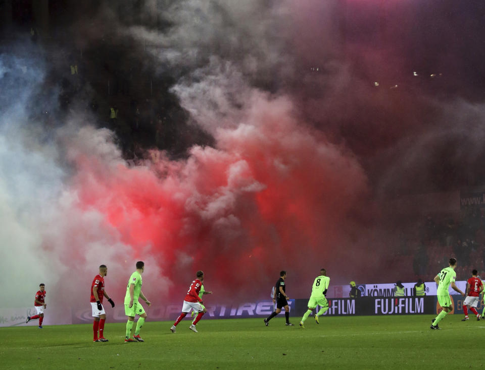 Hannover supporters have lit pyrotchnics during a Bundesliga soccer match between FSV Mainz 05 and Hannnover 96 in Mainz Germany, Sunday, Dec.9, 2018. (Thomas Frey/dpa via AP)