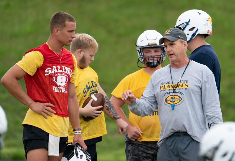 Saline quarterback CJ Carr, left, speaks with head coach Joe Palka, during practice at Saline High School on Monday, Aug. 7, 2023.