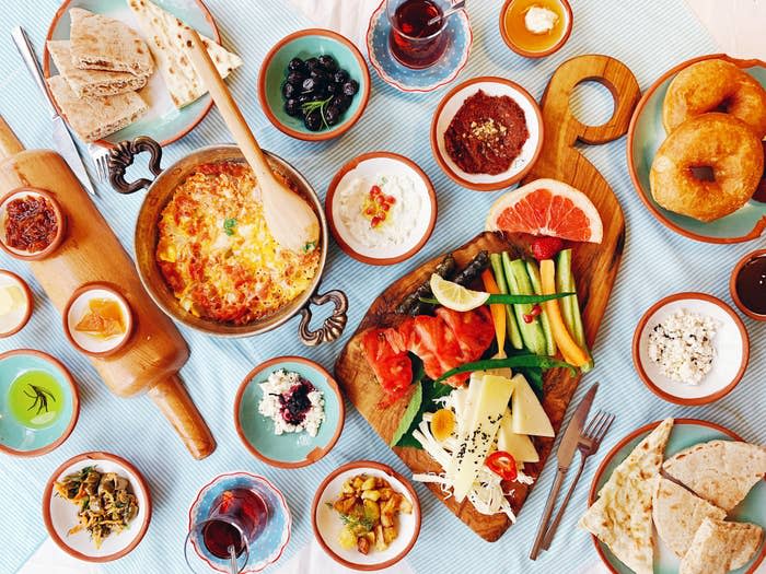 Assorted breakfast items including eggs, bread, cheese and tea on the table