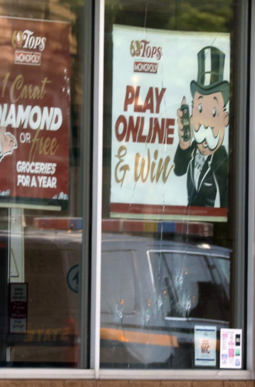 May 15, 2022; Buffalo, NY, USA; Five bullet holes can be seen in the lower part of the window below the Play Online sign at the Tops Friendly Market on Jefferson Ave., in Buffalo, NY on May 15, 2022. 10 people were killed and three others injured in a shooting at the Buffalo grocery store on May 14, 2022. Mandatory Credit: Tina MacIntyre-Yee-USA TODAY NETWORK
