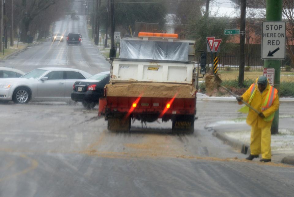 File photo of a city worker putting sand on the road on Kings Highway.