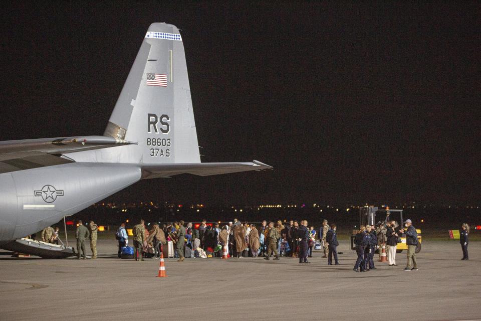 In this Aug. 29 photo families evacuated from Kabul, Afghanistan, walk past a U.S Air Force plane that they arrived on at Kosovo's capital Pristina International Airport.