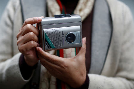 Former employee Huang Caining poses with a Sanyo casette player she used to help make, in front of the Sanyo electronics factory where she worked since 1987, in the Shekou area of Shenzhen, Guangdong Province, China, December 14, 2018. "I came here to see the world. When I signed a three-year contract, I thought I would return home after it ended," Huang said. "Who could have thought that I would end up spending my entire youth here, meeting my significant other, settling down, buying a house and watching our kid coming to this world," she said adding that she would have had none of those opportunities had she stayed in her provincial home town. Picture taken December 14, 2018. REUTERS/Thomas Peter