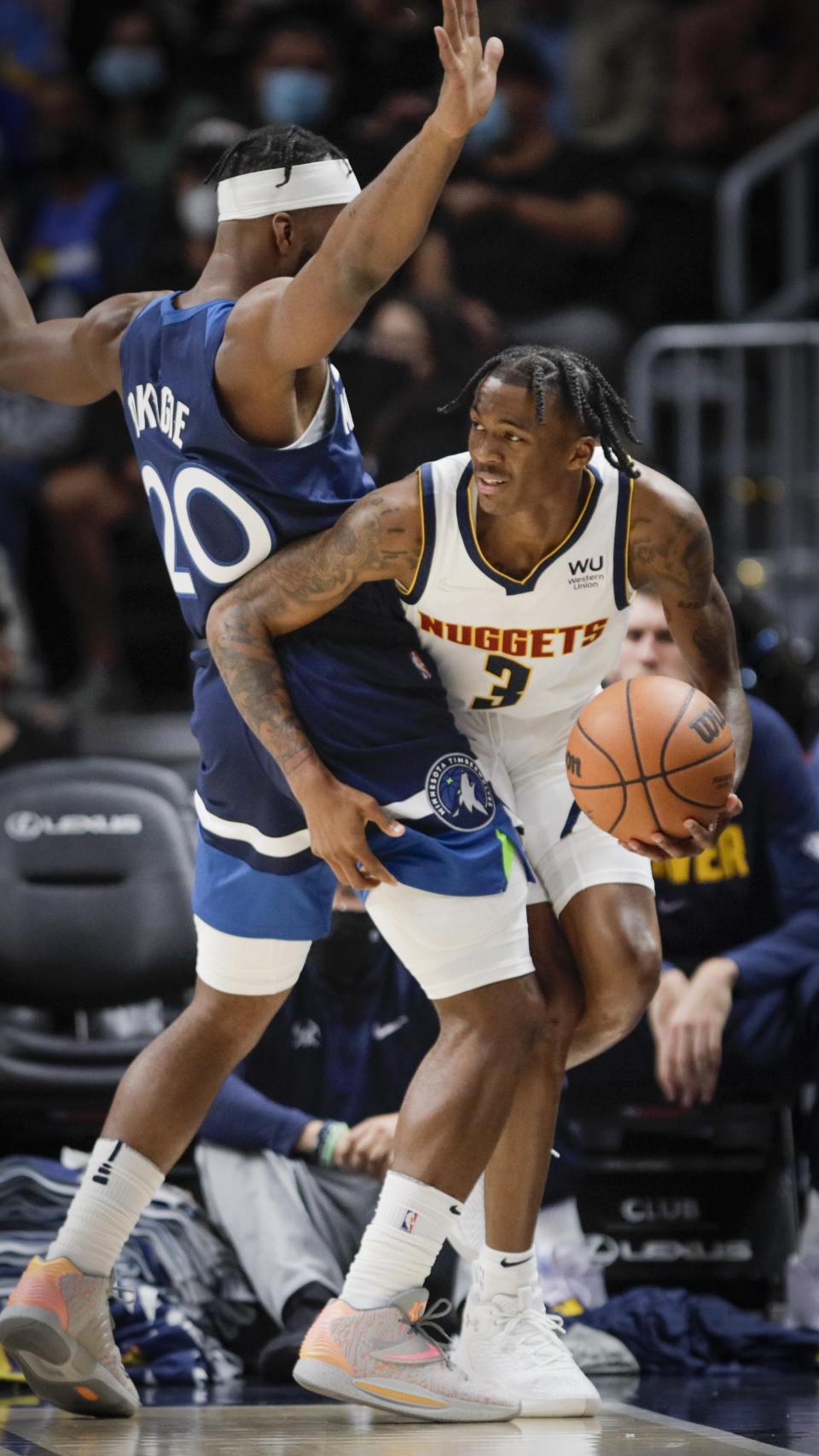 Denver Nuggets guard Nah'Shon Hyland looks to pass around Minnesota Timberwolves forward Josh Okogie (20) in the first quarter of a preseason NBA basketball game in Denver, Friday, Oct. 8, 2021. (AP Photo/Joe Mahoney)