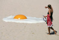 A woman approaches an artwork called "Big Chook", made of fibreglass and high gloss epoxy marine paint, on Tamarama Beach in Sydney November 2, 2005. Australian artist Jeremy Parnell says people frying themselves on the beach for a suntan inspired his piece which joins 100 artworks contributed by international and Australian artists at the annual outdoor Sculpture by the Sea exhibition which is in its ninth year. REUTERS/Will Burgess