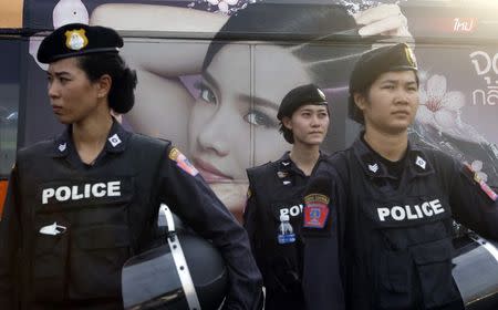 A beauty product advertisement on a passing bus is seen as Thai female riot police take positions to prevent demonstrations against military rule at Victory Monument in Bangkok June 3, 2014. REUTERS/Erik De Castro