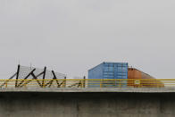 A fuel tanker, cargo trailers and makeshift fencing are used as barricades by Venezuelan authorities attempting to block humanitarian aid entering from Colombia on the Tienditas International Bridge that links the two countries as seen from the outskirts of Cucuta, Colombia, Wednesday, Feb. 6, 2019. Immigration authorities say the Venezuelan National Guard built the roadblock a day earlier. (AP Photo/Fernando Vergara)