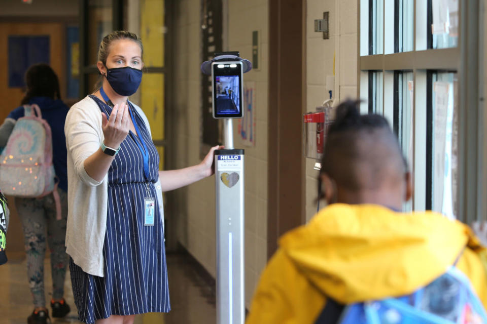 Oct. 6: A teacher at Bielefield Elementary School in Middletown, CT, keeps the line moving as she checks the temperatures of students as they arrive for the day. (Stan Godlewski / Getty Images)