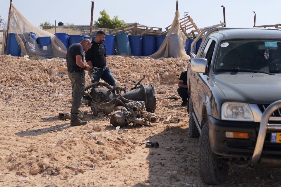 A police officer inspects the remains of a rocket booster near Arad, Israel on April 14, 2024.