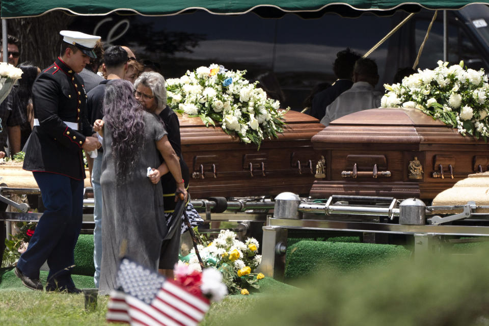 Dos mujeres se consuelan entre sí durante el entierro de Irma Garcia y su esposo Joe Garcia, el miércoles 1 de junio de 2022, en el Cementerio Hillcrest, de Uvalde, Texas. (AP Foto/Jae C. Hong)