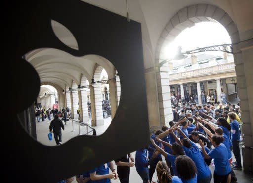 Apple Store employees create a tunnel for customers as they are allowed into the shop to buy the new iPhone 5 at Covent Garden in London