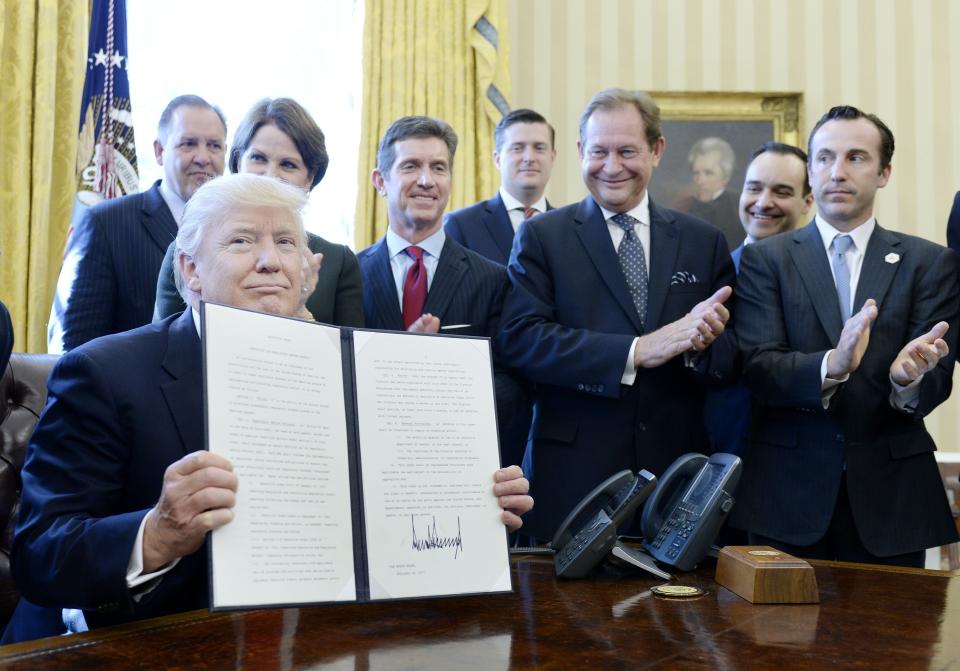 Trump, flanked by business leaders, signs an executive order establishing regulatory reform officers and task forces in U.S. agencies on Feb.&nbsp;24, 2017.