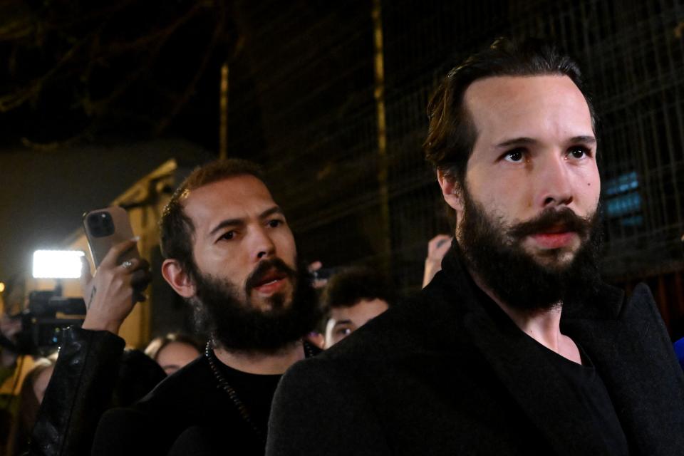 British-US former professional kickboxer and controversial influencer Andrew Tate (L) and his brother Tristan Tate walk out of the central arrest centre of Bucharest police after three months of pre-trial detention, in Bucharest, on late March 31, 2023. - A Romanian court on March 31, 2023 ordered that controversial influencer Andrew Tate and his brother be moved from jail to house arrest while they are investigated for alleged human trafficking and rape. (Photo by Daniel MIHAILESCU / AFP) (Photo by DANIEL MIHAILESCU/AFP via Getty Images)