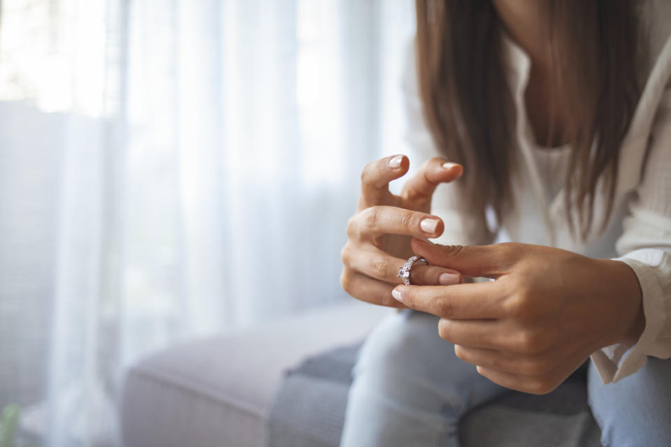 A woman removing her wedding ring