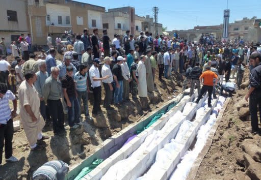 People watch the mass burial of the more than 100 victims of the Houla massacre in Syria on May 26. China on Wednesday restated its opposition to military intervention in Syria, as Russia sought to halt fresh UN Security Council action after the massacre of civilians sparked global fury