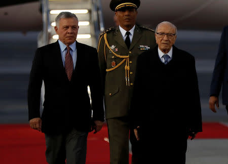 King Abdullah II of Jordan, left, walks next to Tunisian President Beji Caid Essebsi, as they review an honor guard, upon his arrival at Tunis-Carthage international airport to attend the Arab Summit, in Tunis, Tunisia March 30, 2019. Hussein Malla/Pool via REUTERS