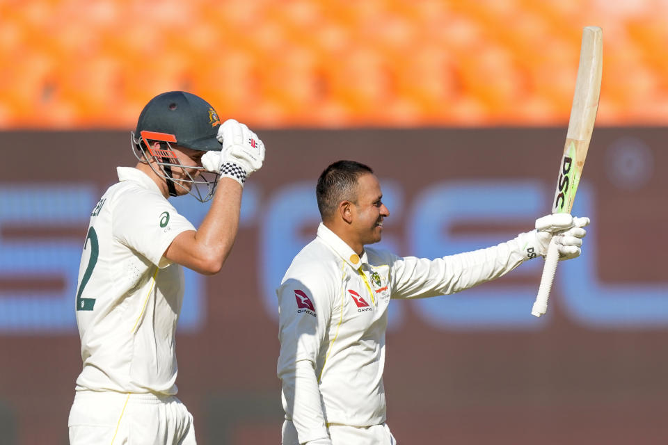 Australia's Usman Khawaja, right, raises his bat to celebrate scoring a century during the first day of the fourth cricket test match between India and Australia in Ahmedabad, India, Thursday, March 9, 2023. (AP Photo/Ajit Solanki)