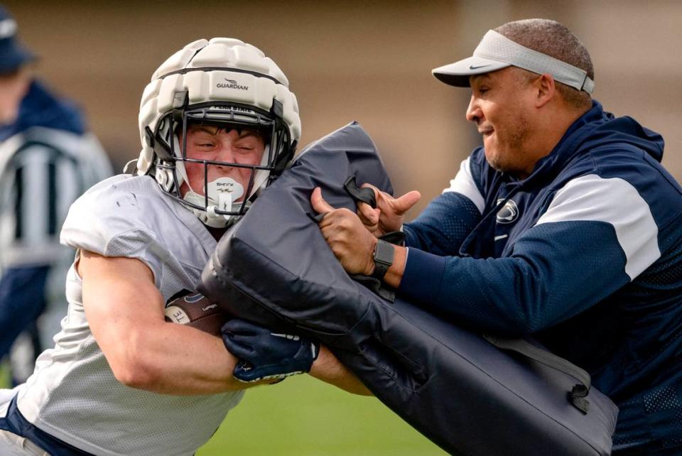 Penn State’s back Tyler Holzworth pushes past running backs coach Ja’Juan Seider during a drill at practice on Tuesday, April 11, 2023.