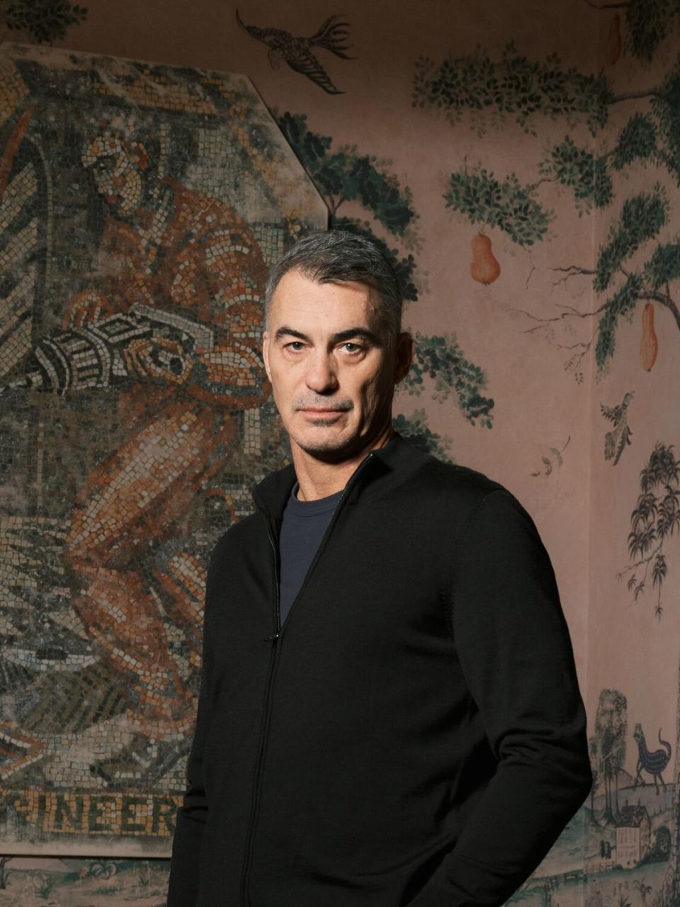 A man stands in a hotel room with floral decor