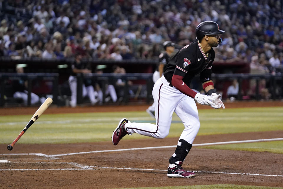 Arizona Diamondbacks' Lourdes Gurriel Jr. tosses his bat away as he watches his sacrifice fly against the Texas Rangers during the fifth inning of a baseball game Tuesday, Aug. 22, 2023, in Phoenix. (AP Photo/Ross D. Franklin)