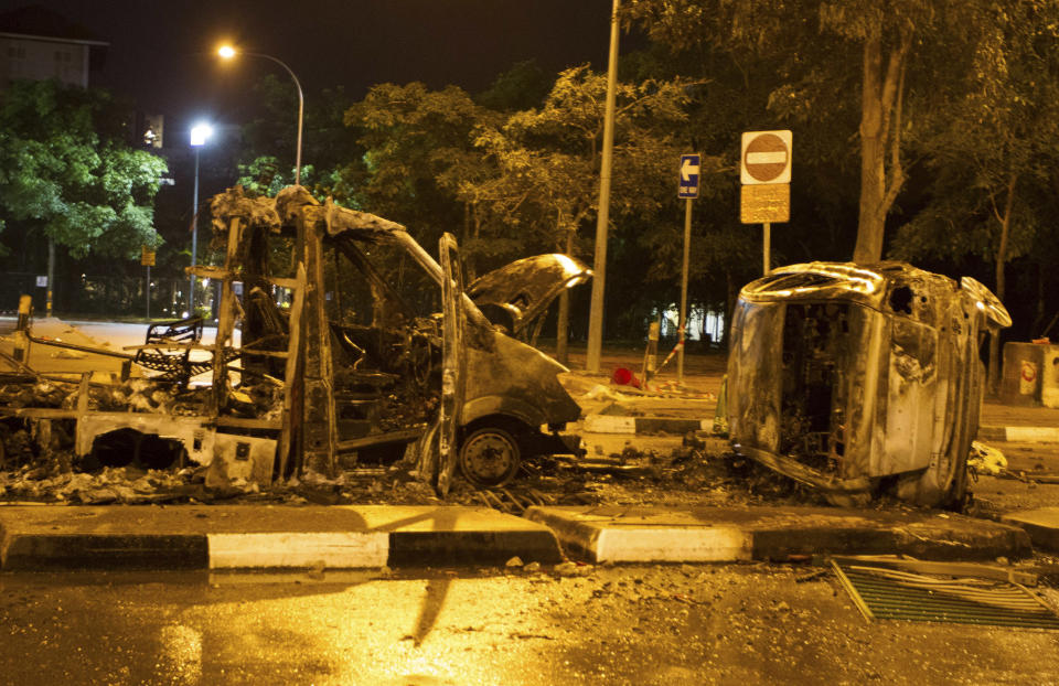 The burnt shells of vehicles are pictured along Race Course Road following a riot near Singapore's Little India district December 9, 2013. Local media said a mob of about 400 set fire to an ambulance and police cars during the riot on Sunday, which started after a bus knocked down a pedestrian. REUTERS/Stringer (SINGAPORE - Tags: CIVIL UNREST)