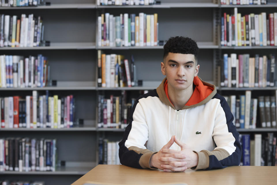 Max Decker, a senior at Lincoln High School, sits for a portrait in the school library where he often worked on writing his college essays, in Portland, Ore., Wednesday, March 20, 2024. (AP Photo/Amanda Loman)