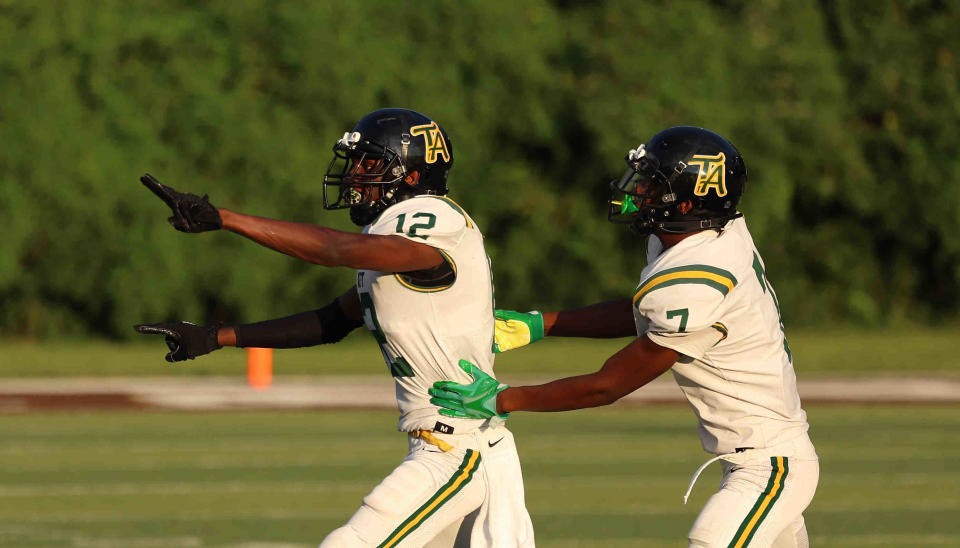 Taft players Quinton Price (12) and Tayshawn Banks (7) celebrate after Price intercepted a pass during their game against Roger Bacon  Thursday, Aug. 18, 2022.