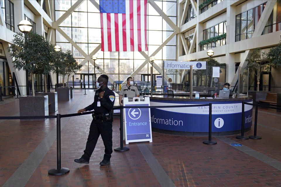 A security guard stands next to the cordoned off atrium, Tuesday, Nov. 30, 2021 at the Hennepin County Government Center in Minneapolis where jury selection begins for former suburban Minneapolis police officer Kim Potter, who says she meant to grab her Taser instead of her handgun when she shot and killed motorist Daunte Wright. (AP Photo/Jim Mone)