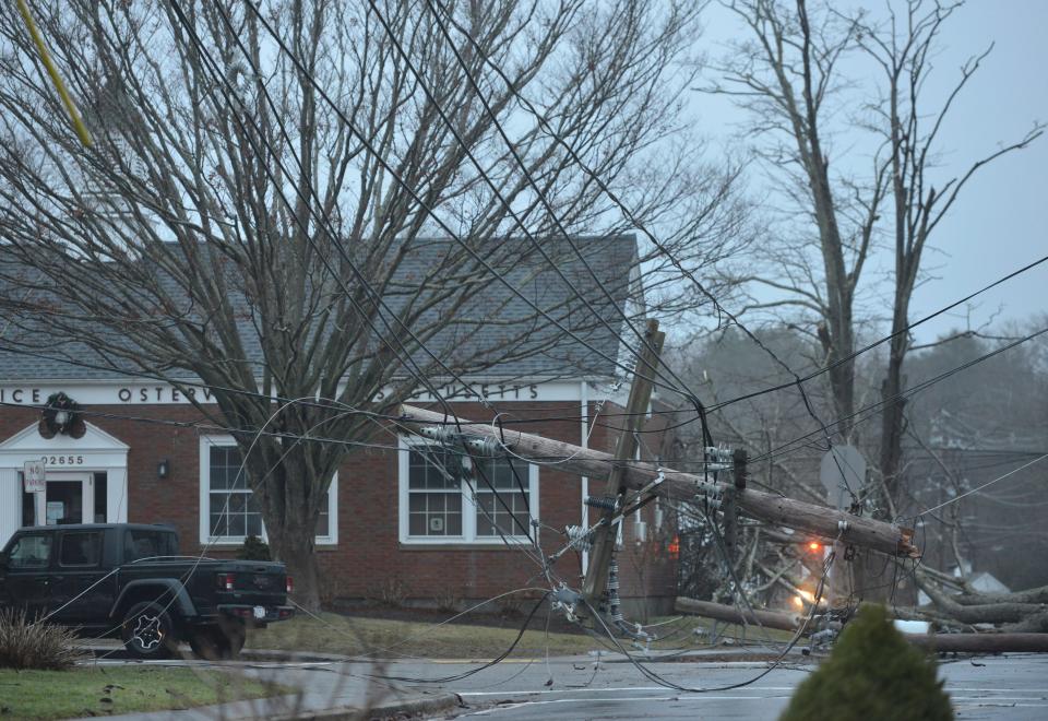 Crews responded to this downed utility pole at the intersection near West Bay Road and Main Street in Osterville. A tree fell on the utility wires Monday during heavy winds and rain.