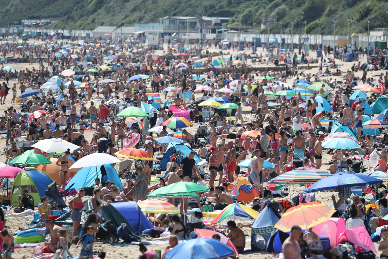 People gather on Bournemouth Beach, following the relaxation of the coronavirus lockdown restrictions in the country, in Bournemouth, England, Tuesday June 2, 2020. (Andrew Matthews/PA via AP)