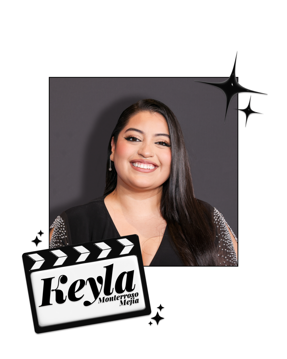 Keyla Monterroso Mejia smiles in front of a gray wall