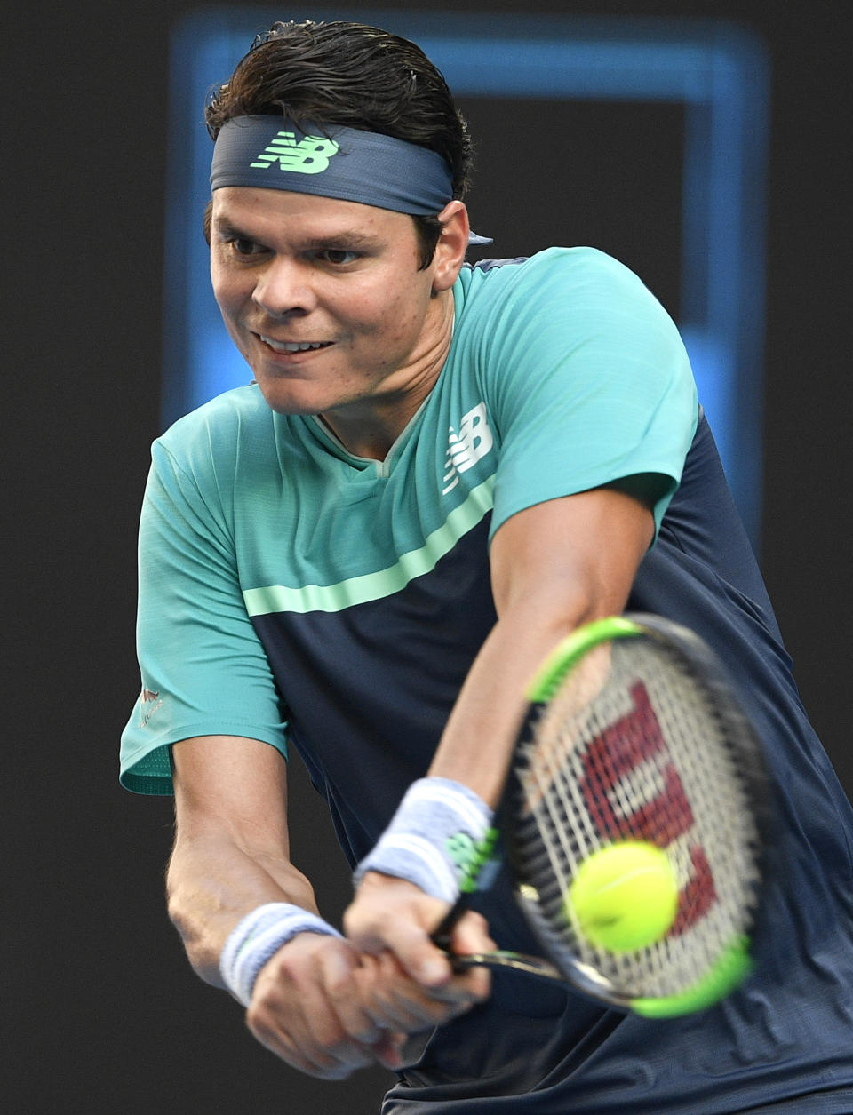 Canada's Milos Raonic makes a backhand return to France's Lucas Pouille during their quarterfinal match at the Australian Open tennis championships in Melbourne, Australia, Wednesday, Jan. 23, 2019. (AP Photo/Andy Brownbill)