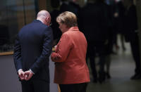 German Chancellor Angela Merkel, right, speaks with European Council President Charles Michel during a round table meeting at an EU summit in Brussels, Thursday, Dec. 12, 2019. European Union leaders gather for their year-end summit and will discuss climate change funding, the departure of the UK from the bloc and their next 7-year budget. (AP Photo/Francisco Seco)