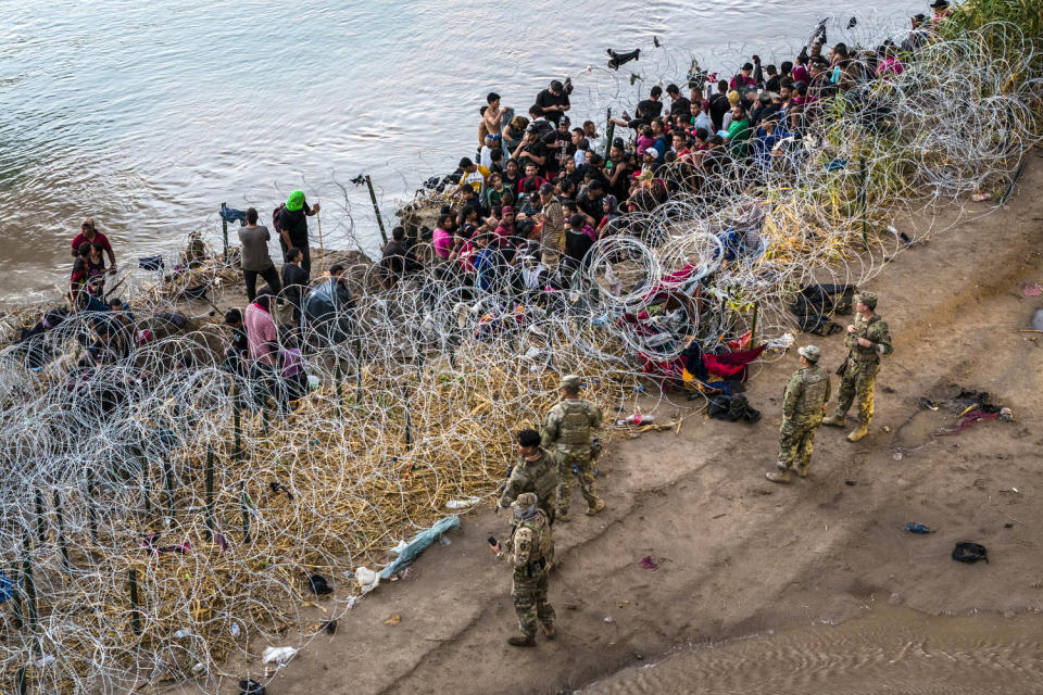 الصورة: الحرس الوطني في تكساس يتفقد المهاجرين الذين يعبرون نهر ريو غراندي إلى الولايات المتحدة من المكسيك (ملف جون مور / غيتي إيماجز)