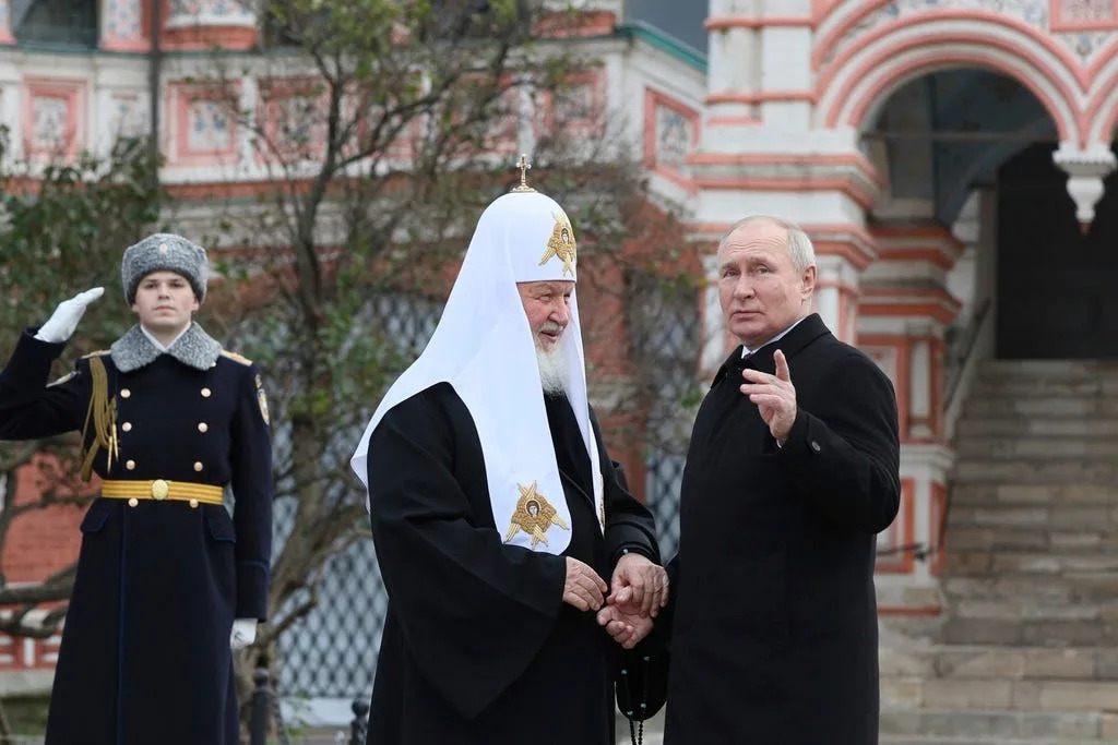 Russian President Vladimir Putin speaks to Russian Orthodox Church Patriarch Kirill at Red Square in Moscow.