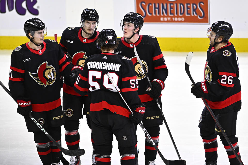 Ottawa Senators defenseman Jacob Bernard-Docker, second right, looks on after scoring against the New Jersey Devils during the third period of an NHL hockey game, Friday, Dec. 29, 2023 in Ottawa, Ontario. (Justin Tang/The Canadian Press via AP)