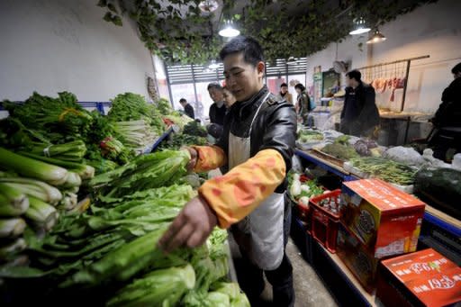 Vendors wait for customers at a vegetable market in southwest China's Chongqing municipality. The government has a difficult tightrope to walk between the perils of slowing growth and the risks of inflation, which it fears as a possible driver of social unrest