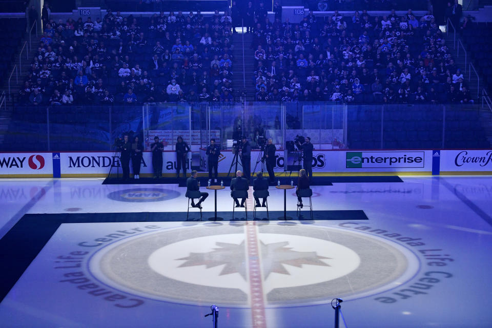 NHL Commissioner Gary Bettman, center right, and Deputy Commissioner Bill Daly, center left, along with Winnipeg Jets co-owner Mark Chipman, left, speak to season-ticket holders before an NHL hockey game between the St. Louis Blues and the Winnipeg Jets on Tuesday, Feb. 27, 2024, in Winnipeg, Manitoba. (Fred Greenslade/The Canadian Press via AP)