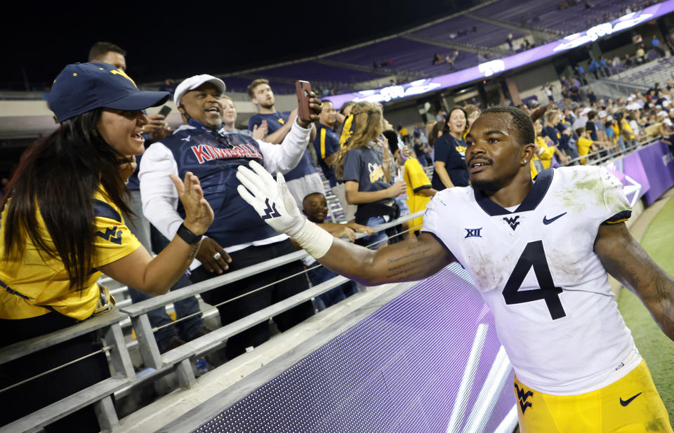 West Virginia running back Leddie Brown (4) celebrates with fans following a win over TCU in an NCAA college football game Saturday, Oct. 23, 2021, in Fort Worth, Texas. AP Photo/Ron Jenkins)