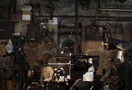 A worker makes parts of a drilling machine at a workshop in the old quarters of Delhi November 12, 2013. REUTERS/Adnan Abidi/Files