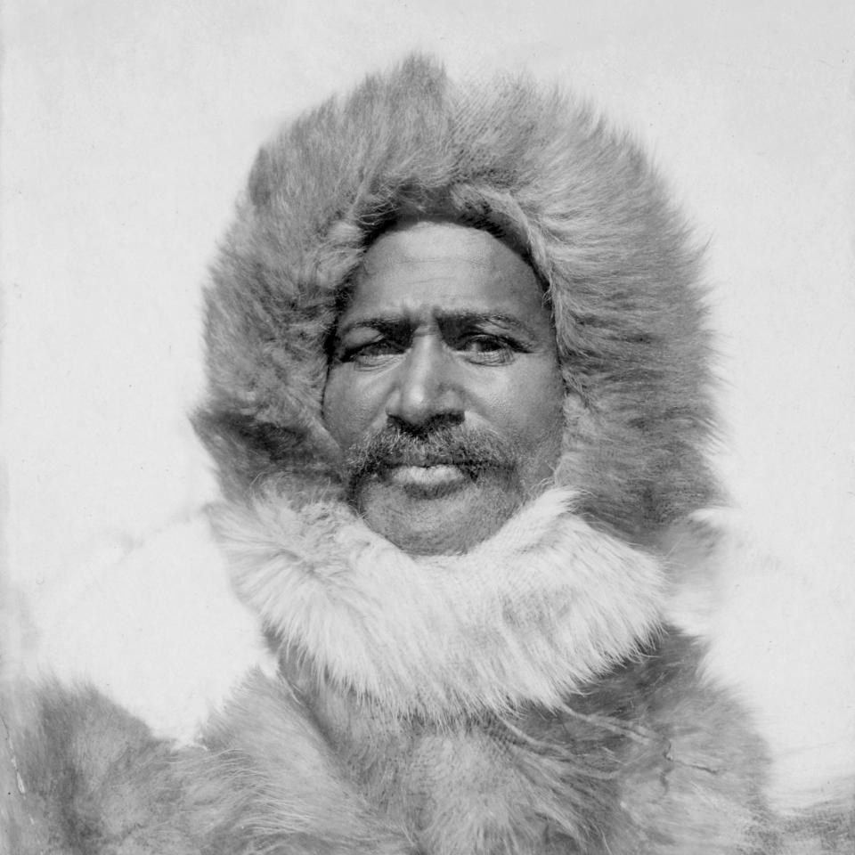 Matthew Henson poses for a portrait in his fur coat with collar, circa 1910