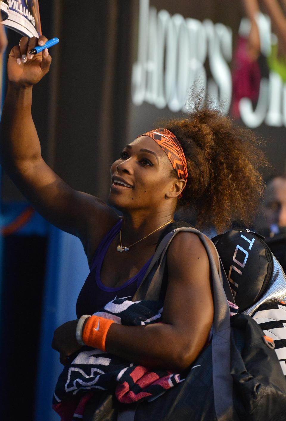 Serena Williams of the US signs autographs after her victory against Russia's Maria Kirilenko during their women's singles match on day eight of the Australian Open tennis tournament in Melbourne on January 21, 2013.