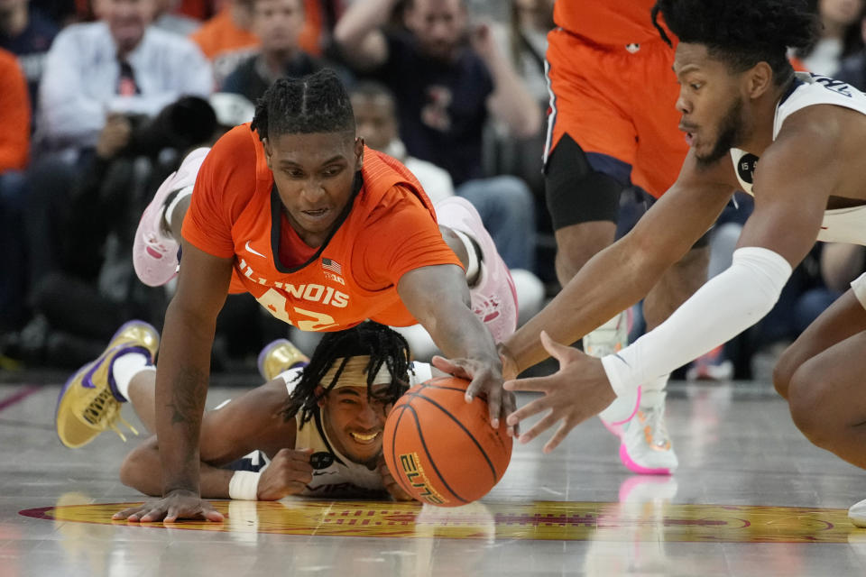 Illinois' Dain Dainja, top, dives over Virginia's Armaan Franklin, bottom, during the second half of an NCAA college basketball game Sunday, Nov. 20, 2022, in Las Vegas. (AP Photo/John Locher)