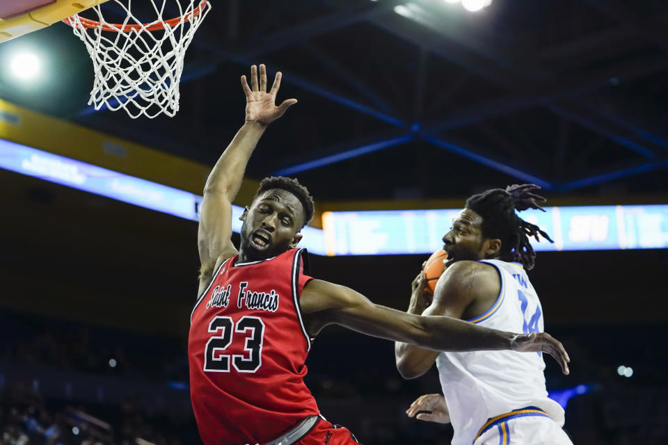 St. Francis guard Wisler Sanon II, left, defends as UCLA forward Kenneth Nwuba drives the ball during the first half of an NCAA college basketball game, Monday, Nov. 6, 2023, in Los Angeles. (AP Photo/Ryan Sun)