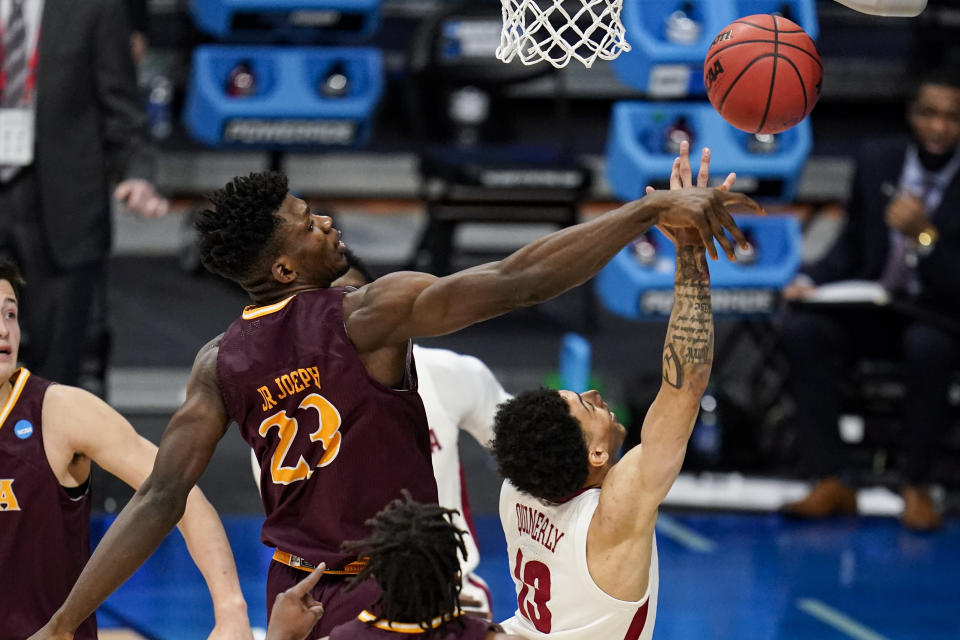 Iona forward Nelly Junior Joseph (23) blocks the shot of Alabama guard Jahvon Quinerly (13) in the first half of a first-round game in the NCAA men's college basketball tournament at Hinkle Fieldhouse in Indianapolis, Saturday, March 20, 2021. (AP Photo/Michael Conroy)