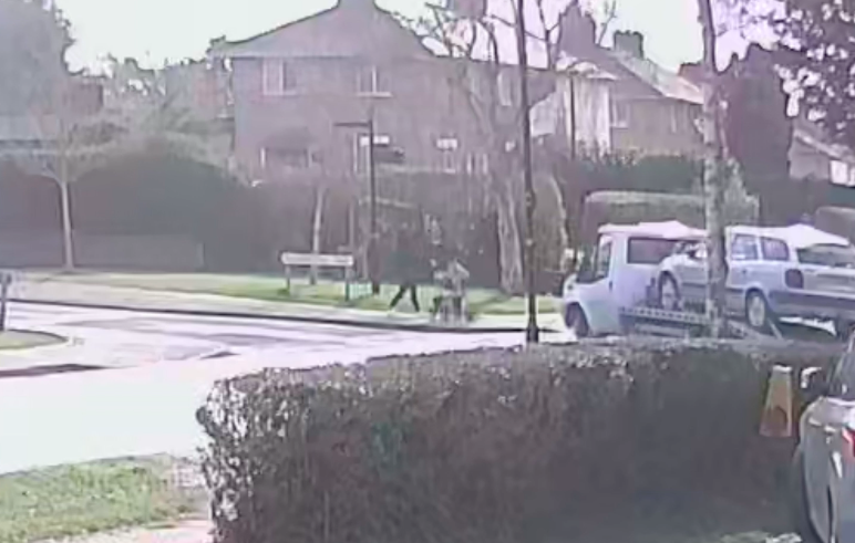 A van transporting a car on a trailer turns in front of the mother and her baby. (SWNS)