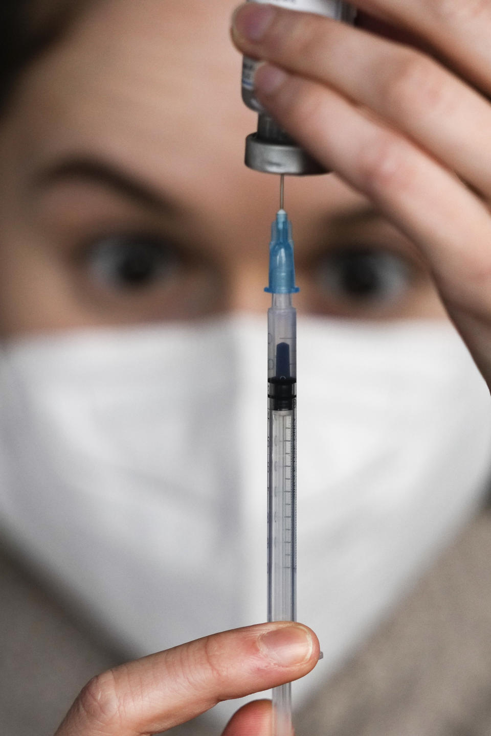 FILE - Medical staff prepares a syringe with vaccination against the coronavirus and the COVID-19 disease inside Klunkerkranich Restaurant and night club during an ongoing vaccination campaign of the Clubkommission in Berlin, Germany, Wednesday, Jan. 5, 2022. Germany's parliament is set to hold its first debate Wednesday on a possible wide-ranging coronavirus vaccine mandate, with three options emerging: obligatory vaccinations for all adults or for everyone above 50, or no mandate at all. (AP Photo/Markus Schreiber, File)